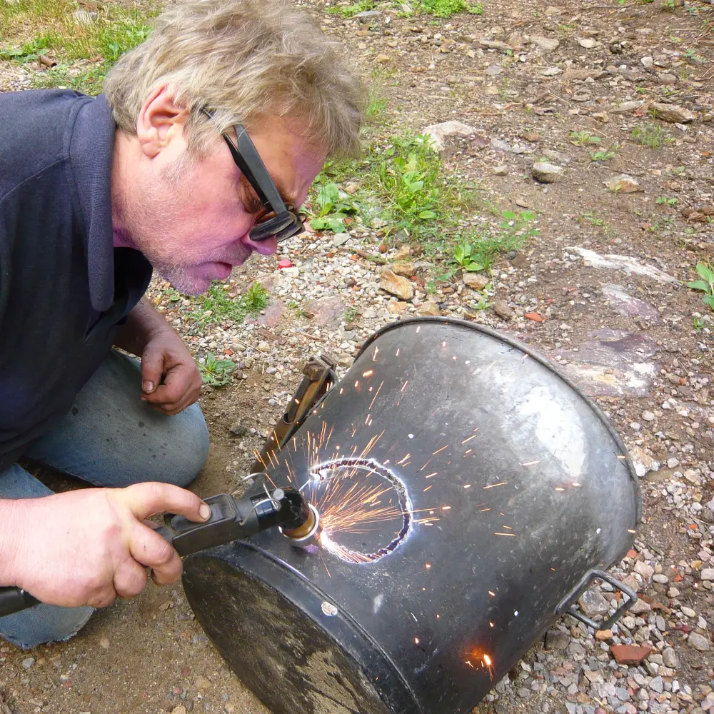 Maarten découpe l'entrée de la flamme du bruleur qui sera orienté de façon à tourner sur la paroi